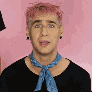 a man with pink hair and a blue bandana around his neck .