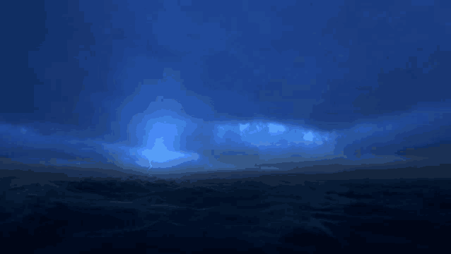 a lightning bolt strikes over a body of water at night
