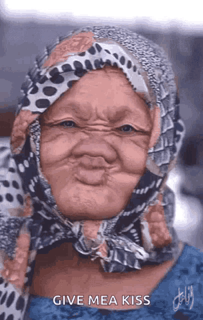 an elderly woman wearing a scarf around her head is making a funny face and says give me a kiss .