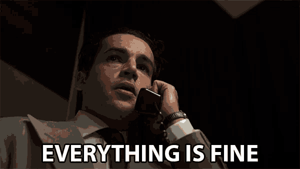 a man in a suit and tie talking on a cell phone with the words everything is fine written below him