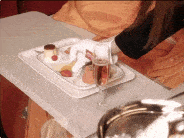a tray of food on a table with a glass of wine