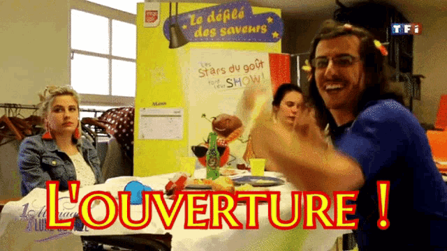 a man and a woman are sitting at a table with l' ouverture written on the table