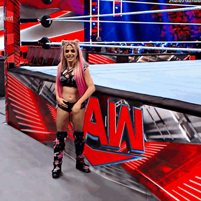 a woman stands in front of a sign that says aw