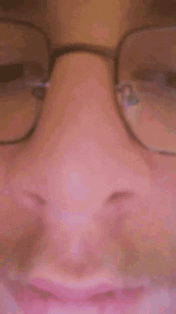 a man with glasses and a beard is smiling