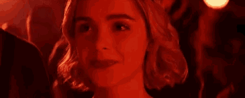 a close up of a woman 's face in a dark room in a red light .