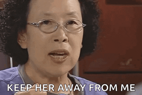 an older woman wearing glasses is talking and says `` keep her away from me '' .