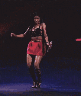 a woman in a red skirt is dancing on a stage with blue lights behind her