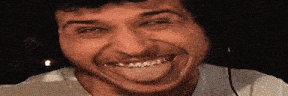 a man is smiling and making a funny face with his mouth open .