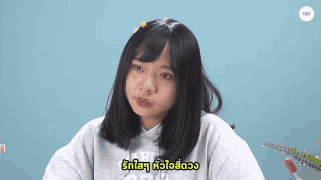 a girl wearing a grey north face sweatshirt is making a face
