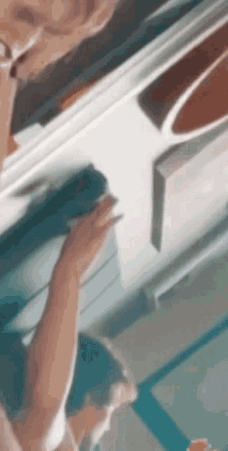 a blurry picture of a person cleaning a door with a sponge