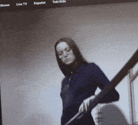 a woman in a blue shirt is standing on a set of stairs in front of a tubi kids page