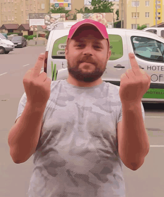 a man giving the middle finger in front of a van that says hotel