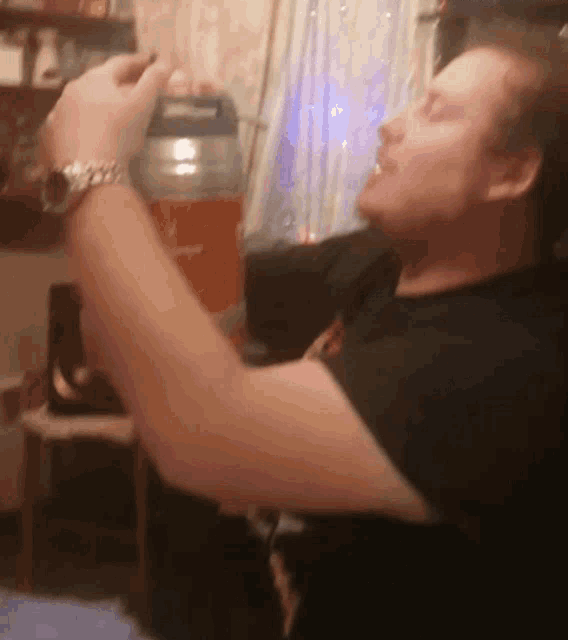 a man with a watch on his wrist is drinking from a container