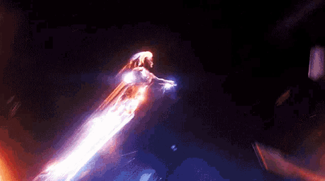 a person is flying through the air in the dark with a light coming out of their mouth .
