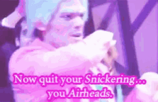 a man with blue hair is holding a piece of paper and says now quit your snickering you airheads .