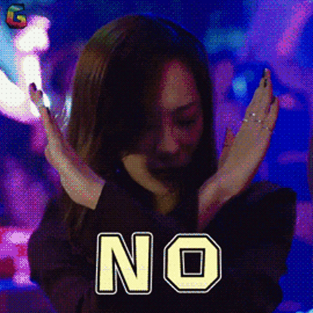 a woman in a dark room with the word no on her chest
