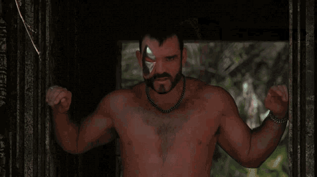 a shirtless man with a mask on his face is standing in front of a window