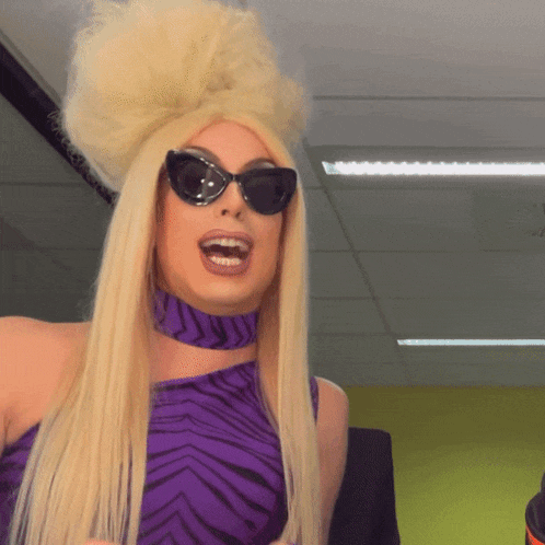 a drag queen wearing sunglasses and a zebra print dress
