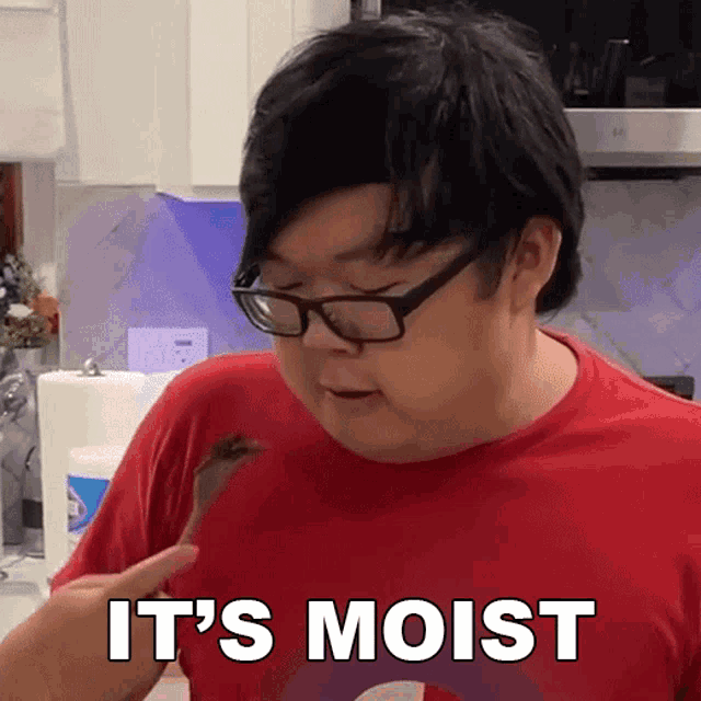 a man with glasses and a red shirt says it 's moist in white letters