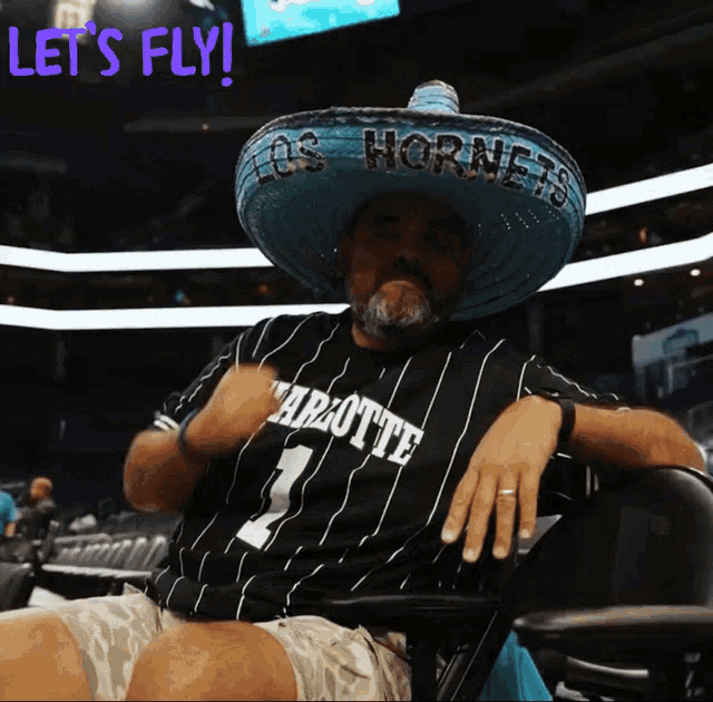 a man wearing a sombrero and a charlotte jersey says let 's fly
