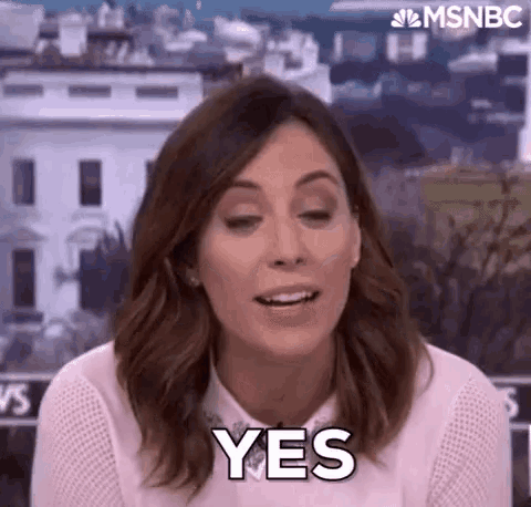 a woman is sitting in front of a white house and making a yes gesture .