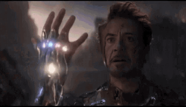 a close up of a man 's hand with the infinity gauntlet in it
