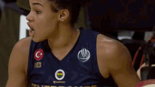 a female basketball player wearing a blue shirt with the letter c on the front