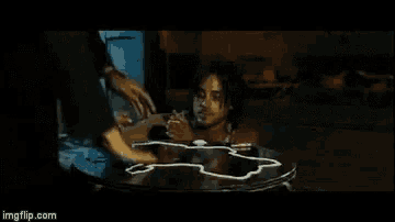 a man in a bathtub is being served a cup of coffee by a waiter .