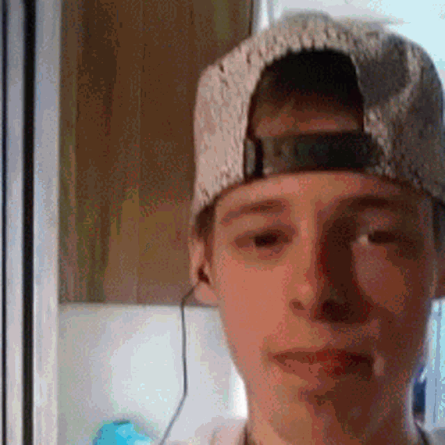 a young boy wearing a baseball cap and ear buds