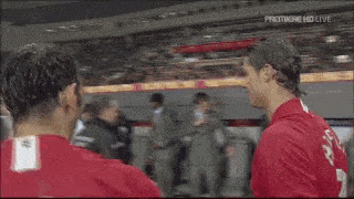 a man wearing a manchester united shirt holds his head