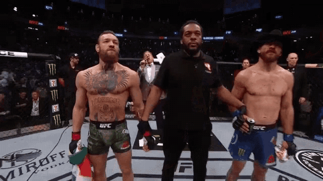 a man in a cowboy hat is standing next to a man in a ufc uniform