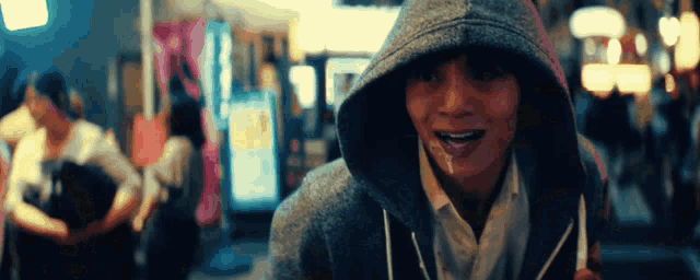 a person wearing a hooded sweatshirt with their mouth full of milk