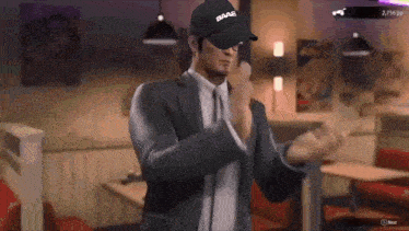 a man in a suit is wearing a baa2 baseball cap