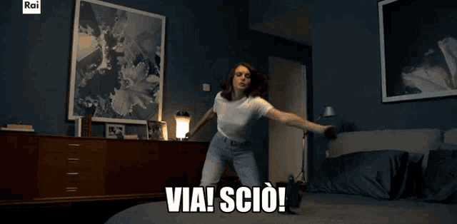 a woman in a white shirt is dancing in a bedroom with the words via scio written on the bottom