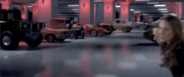 a woman stands in front of a parking garage with cars parked in rows