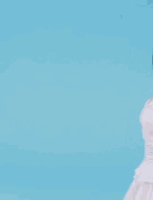 a woman is wearing a white dress and smiling .