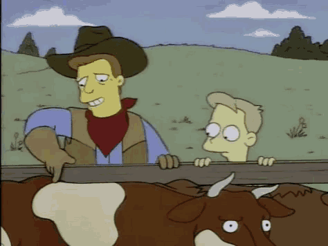a man in a cowboy hat is standing next to a cow .