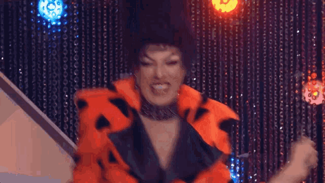a drag queen wearing a flintstones costume is dancing on a stage