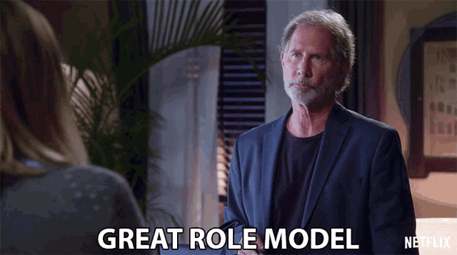 a man in a suit talks to a woman and says " great role model "