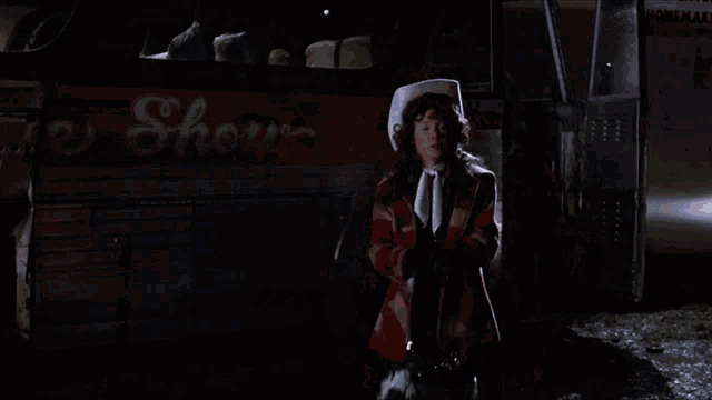 a woman wearing a cowboy hat is standing in front of a sign that says coca cola