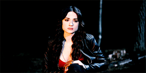 a woman wearing a red top and a leather jacket