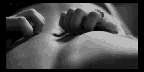 a black and white photo of a person 's hands on a woman 's belly .