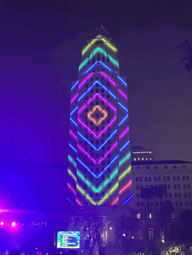 a large building is lit up at night with a geometric pattern on it