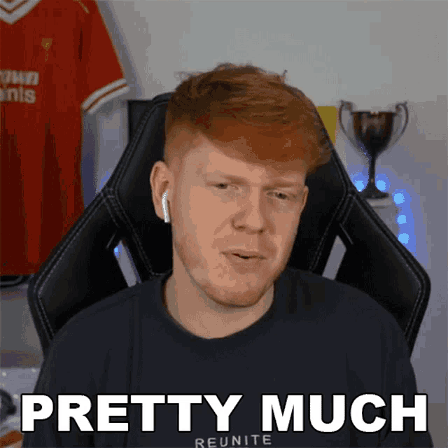 a man with red hair is wearing ear buds and a black shirt that says pretty much