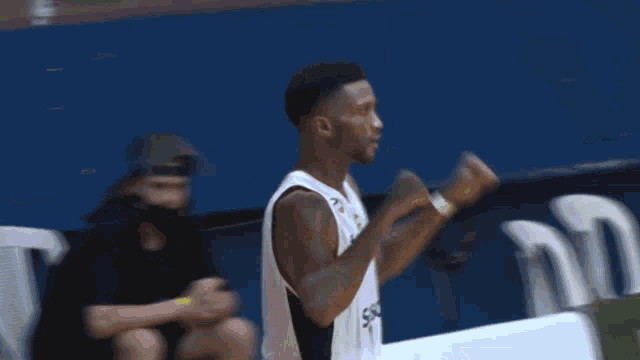 two basketball players high five each other in front of a sign that says ' jate '