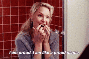 a woman is brushing her teeth in front of a mirror and saying i am proud i am like a proud mama