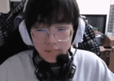 a young boy wearing headphones and glasses is sitting in front of a computer screen .