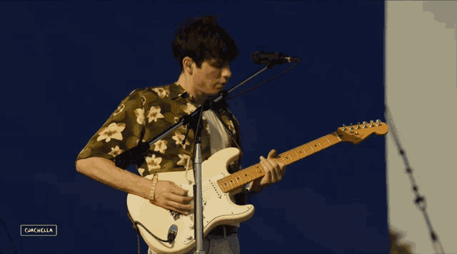 a man is playing a guitar and singing into a microphone at a festival called cancabella