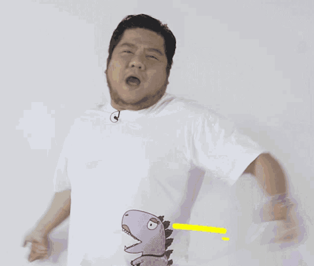 a man wearing a white t-shirt with a purple dinosaur on his stomach