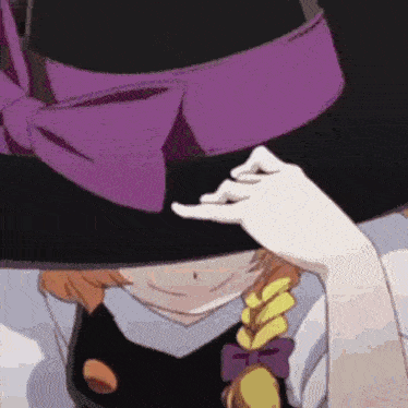 a close up of a person wearing a hat with a purple bow .